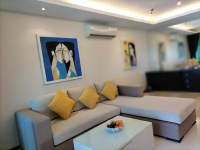 a living room with a couch and a table at Modern 2-Bedroom Condo in Kamala Near the beach in Kamala Beach