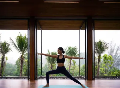 a woman doing a yoga pose in a room with windows at Phuket V Building 19 Villas with Andaman Sea View Private Swimming Pool and Spa in Ban Ao Makham