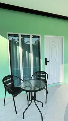 a glass table and two chairs on a patio at The Saii in Ko Yao Yai