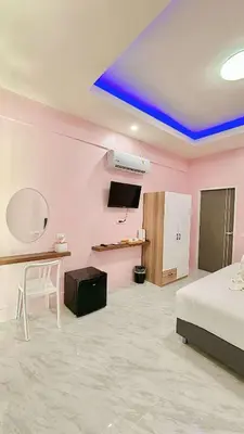 a room with pink walls and a bed and a table at The Saii in Ko Yao Yai