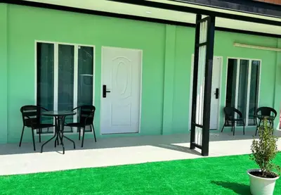 a patio with a table and chairs and a green wall at The Saii in Ko Yao Yai