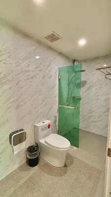a bathroom with a toilet and a green glass door at The Saii in Ko Yao Yai