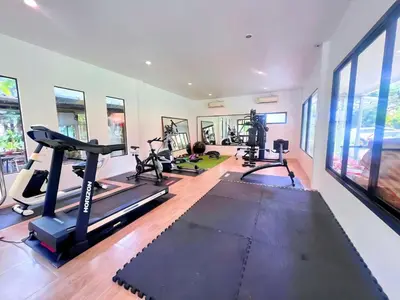 a gym with treadmills and ellipticals in a room at OYA International Resort Phuket \u666e\u5409\u5c9b\u6b27\u96c5\u56fd\u9645\u5ea6\u5047\u9152\u5e97 in Phuket Town