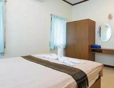 a bedroom with a bed with white towels on it at OYA International Resort Phuket \u666e\u5409\u5c9b\u6b27\u96c5\u56fd\u9645\u5ea6\u5047\u9152\u5e97 in Phuket Town