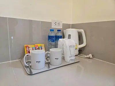 a tray with three coffee cups and bottles of water at OYA International Resort Phuket \u666e\u5409\u5c9b\u6b27\u96c5\u56fd\u9645\u5ea6\u5047\u9152\u5e97 in Phuket Town