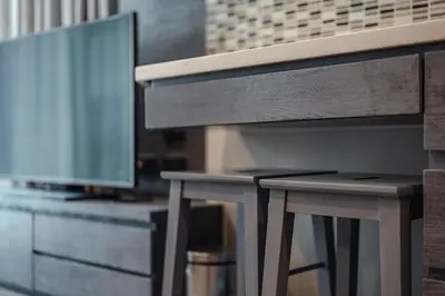 two wooden stools next to a tv and a desk at C161 1Km to beach New City gate in Kamala Beach