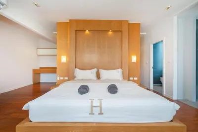 a bedroom with a large white bed with two hats on it at 650m to beach condofast WiFi in Kamala Beach