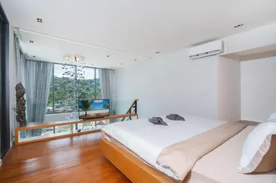 a bedroom with a bed and a large window at 650m to beach condofast WiFi in Kamala Beach