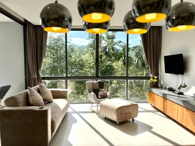 a living room with a couch and chairs and a large window at 650m to beach condofast WiFi in Kamala Beach