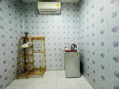 a kitchen with a refrigerator and a wall at Navy Guesthouse in Ban Laem Sai