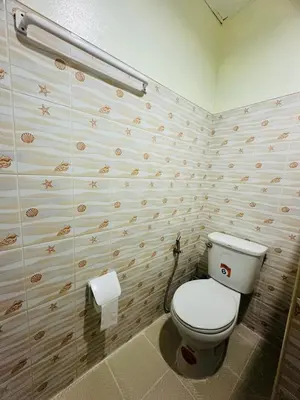 a bathroom with a toilet and a roll of toilet paper at Navy Guesthouse in Ban Laem Sai