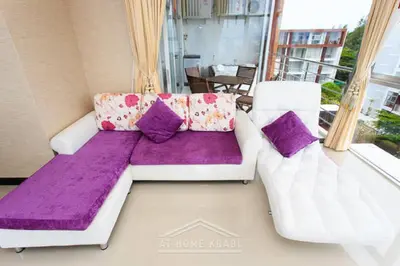 a living room with a white couch and purple pillows at At Sea Condotel in Klong Muang Beach