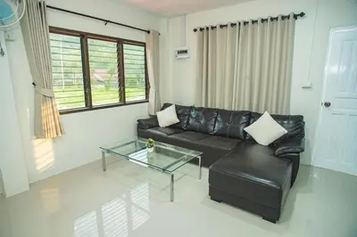 a living room with a leather couch and a glass table at Songbird Suites - Deluxe Twin Suite and Scooter in Ao Nang Beach