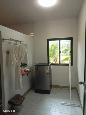 a bathroom with a white robe hanging on a wall at Koh Yao Yai Resort Ta & Yai ที่พักเกาะยาวใหญ่ตากับยายรีสอร์ท in Ban Lo Pa Ret
