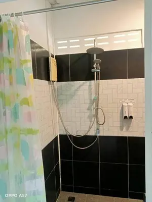 a shower in a bathroom with black and white tiles at Koh Yao Yai Resort Ta & Yai ที่พักเกาะยาวใหญ่ตากับยายรีสอร์ท in Ban Lo Pa Ret
