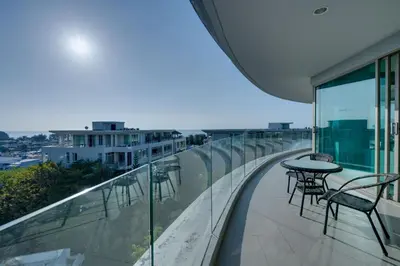a balcony with tables and chairs on a building at Veloche Apartment by Continent in Karon Beach