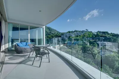 a balcony with a table and chairs and a view at Veloche Apartment by Continent in Karon Beach