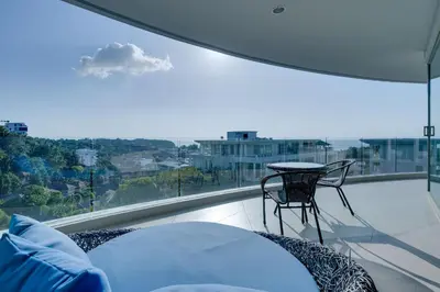 a balcony with a table and a chair and a window at Veloche Apartment by Continent in Karon Beach