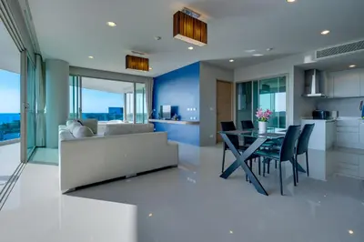 a living room with a couch and a table with chairs at Veloche Apartment by Continent in Karon Beach