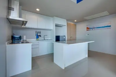 a kitchen with white cabinets and a white counter top at Veloche Apartment by Continent in Karon Beach