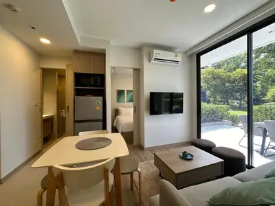 a living room with a couch and a table at 2 BD Skypark Condo with Terrace in Laguna Phuket