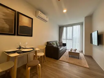 a living room with a couch and a table with chairs at 1 BD Laguna Skypark Golf Course View in Phuket