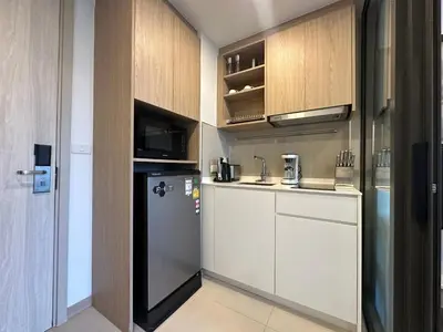 a kitchen with white cabinets and a refrigerator at 1 BD Laguna Skypark Golf Course View in Phuket