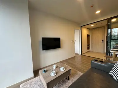 a living room with a couch and a table at 1 BD Laguna Skypark Golf Course View in Phuket