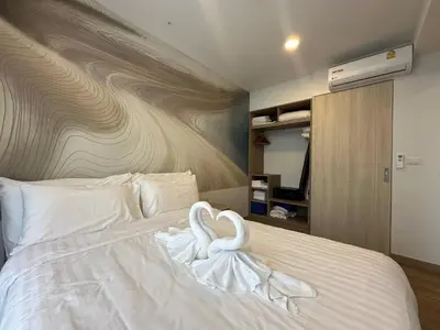two white swans sitting on top of a bed at 1 BD Laguna Skypark Golf Course View in Phuket