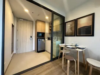 a kitchen and dining room with a table and chairs at 1 BD Laguna Skypark Golf Course View in Phuket
