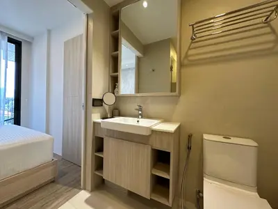 a bathroom with a sink and a toilet and a mirror at 2 BD Skypark Condo in Laguna Phuket