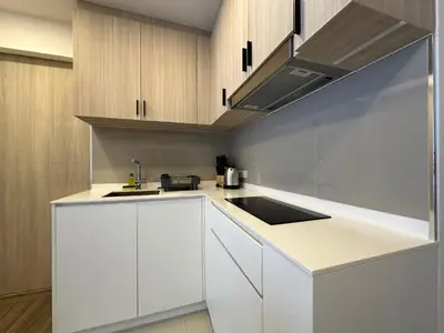 a kitchen with white cabinets and a sink at 2 BD Skypark Condo in Laguna Phuket