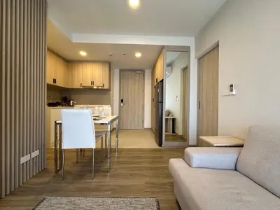 a living room and kitchen with a couch and a table at 2 BD Skypark Condo in Laguna Phuket
