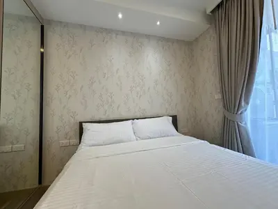 a bedroom with a large bed with a window at 2 BD Skypark Condo in Laguna Phuket