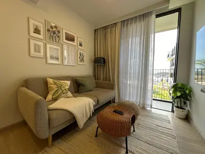 a living room with a couch and a window at 2 BD Laguna Skypark Condo in Phuket