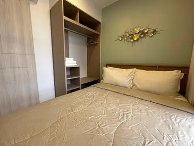 a bedroom with a bed and a chandelier on the wall at 2 BD Laguna Skypark Condo in Phuket