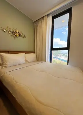 a bedroom with a large bed with a window at 2 BD Laguna Skypark Condo in Phuket