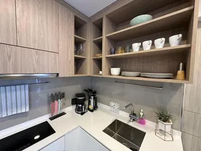 a kitchen with a sink and wooden cabinets at 2 BD Laguna Skypark Condo in Phuket