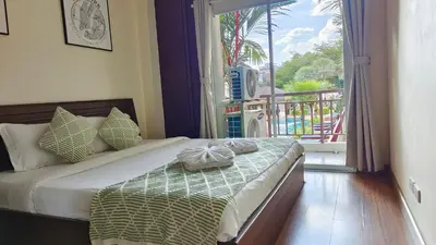 a bedroom with a bed with a view of a balcony at \u82ad\u4e1c43\u5e02\u4e2d\u5fc3\u6cf3\u6c60\u666f\u4e24\u5367\u5ba4\u516c\u5bd3\u8fd1\u73ed\u8d5e\u6c5f\u897f\u51b7\u9152\u5427\u8857 in Patong Beach