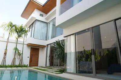 a house with a swimming pool and palm trees at Zenithy Villas 3BD in Phuket
