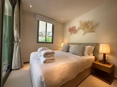 a bedroom with a bed with towels on it at Trichada Sky 3BD in Phuket