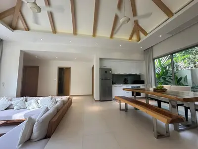 a living room with a long couch and a table at Trichada Sky 3BD in Phuket