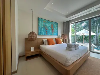 a bedroom with a bed and a large window at Trichada Sky 3BD in Phuket
