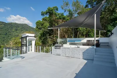 a large deck with a sink and a large umbrella at Amor Primero - sea view pool villa with maid in Kamala Beach