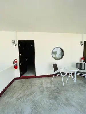 a white room with a table and a chair at Coral Retreat Koh Yao Yai in Ko Thanan