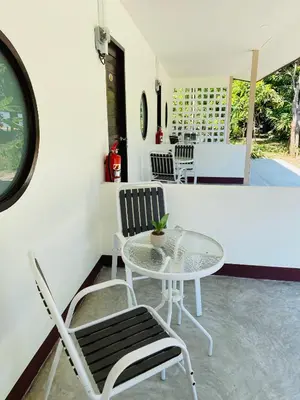 a patio with a table and chairs in a room at Coral Retreat Koh Yao Yai in Ko Thanan