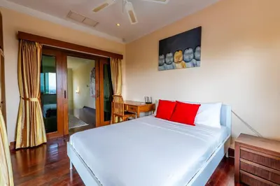a bedroom with a white bed with red pillows at Luxurious Phuket Escape - Lakewood Hills in Layan Beach
