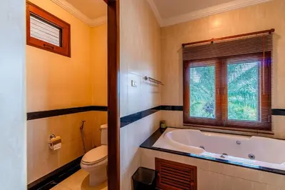 a bathroom with a tub and a toilet and a window at Luxurious Phuket Escape - Lakewood Hills in Layan Beach