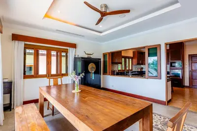 a dining room with a table and a ceiling fan at Luxurious Phuket Escape - Lakewood Hills in Layan Beach