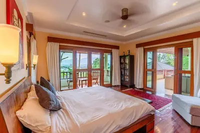 a bedroom with a large bed and some windows at Luxurious Phuket Escape - Lakewood Hills in Layan Beach